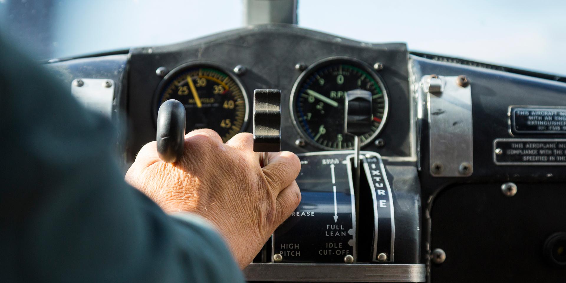 pilot hand pushing a lever in a plane cockpit